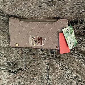 A light tan colored wallet/purse made by Badgley Mischka